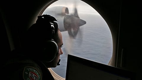 FILE - Flight officer Rayan Gharazeddine scans the water in the southern Indian Ocean off Australia from a Royal Australian Air Force AP-3C Orion during a search.