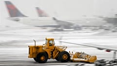 Un chasse-neige dégage la piste lundi 3 février 2014 à l’aéroport international Newark-Liberty, à Newark (New Jersey). Jusqu’à 13 cm de neige sont attendus à Newark.