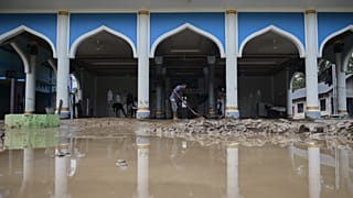 People clean up mud from a mosque at a village affected by the floods in Pidie Jaya, Aceh province, Indonesia, Wednesday, Dec. 3, 2025.