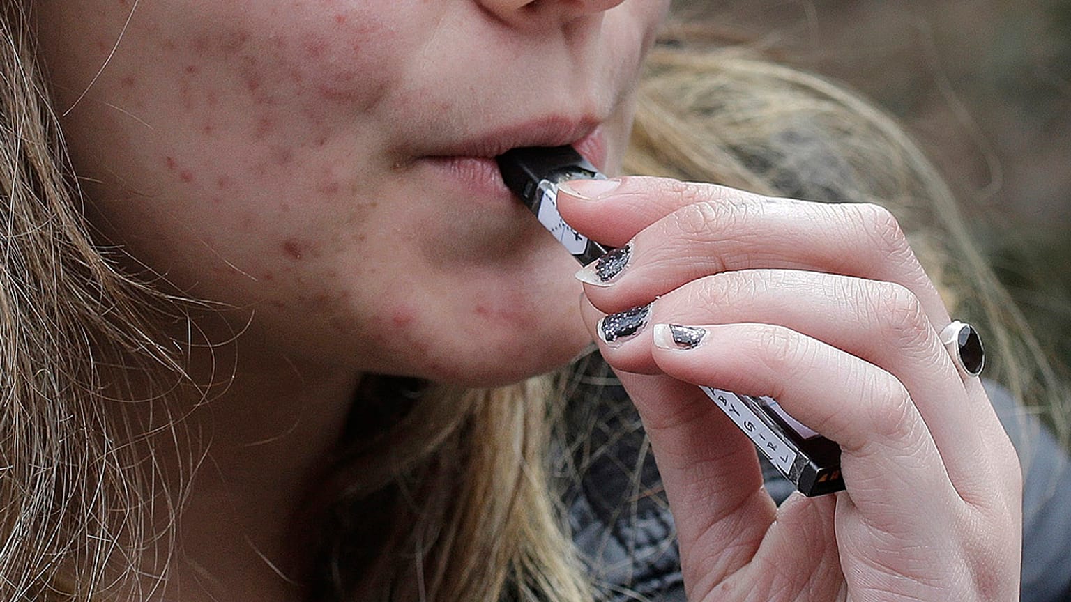 A high school student using a vape device.