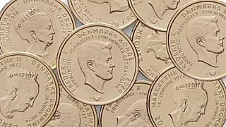Las monedas antiguas con la imagen de la reina Margarita II, versus la nueva moneda con el rey Federico X. 