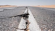Bu stok fotoğrafta bir kara yolunda deprem sonrası yarıklar oluştuğu görülüyor.
