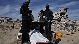 يحمل مقاتلون من حركة الجهاد الإسلامي وحماس كيسًا أبيض يُعتقد أنه يحتوي على رفات رهينة، في بلدة بيت لاهيا شمال قطاع غزة، الأربعاء 3 ديسمبر/كانون الأول 2025.