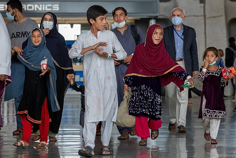 خانواده‌های تخلیه‌شده از کابل، افغانستان، روز سه‌شنبه ۳۱ اوت ۲۰۲۱، پس از رسیدن به فرودگاه بین‌المللی واشنگتن دالس در چنتیلی، ویرجینیا، ا