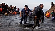 Migrants and refugees arrive on a dinghy after crossing from Turkey to Lesbos island, Greece, Sept. 9, 2015. 