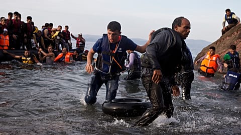 Migrantes e refugiados chegam num bote depois de atravessarem da Turquia para a ilha de Lesbos, na Grécia, a 9 de setembro de 2015. 