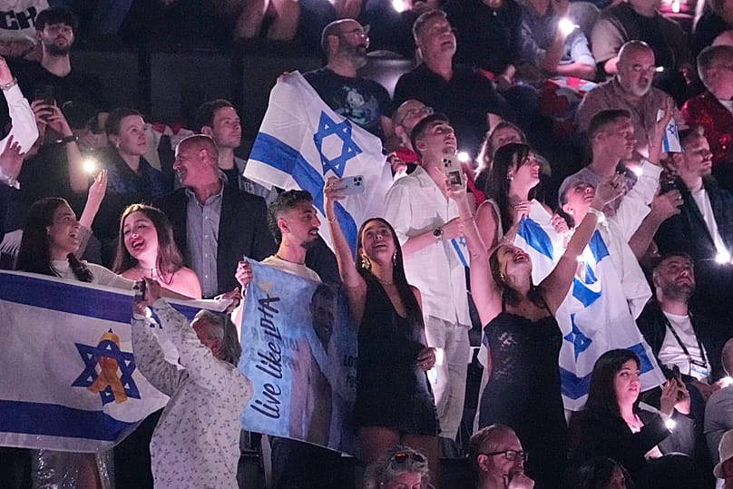 İsviçre’nin Basel kentinde düzenlenen 69. Eurovision Şarkı Yarışması’nın yarı finalinde sahne almasının ardından, İsrailli hayranlar İsrail’den Yuval Raphael’i tezahüratlarla destekliyor, 15 Mayıs 2025. 