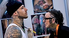 Eine Frau arbeitet an einem Kunden während der Gods of Ink Tattoo Convention mit 400 internationalen Tätowierern in Frankfurt, Deutschland.