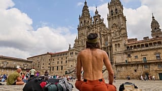 Peregrinos descansan ante la Catedral de Santiago de Compostela