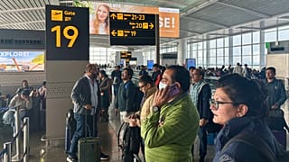 Passengers wait outside the Indira Gandhi International Airport in New Delhi, India, as several Indigo Airlines flights were either cancelled or delayed.