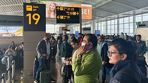Passengers wait outside the Indira Gandhi International Airport in New Delhi, India, as several Indigo Airlines flights were either cancelled or delayed.