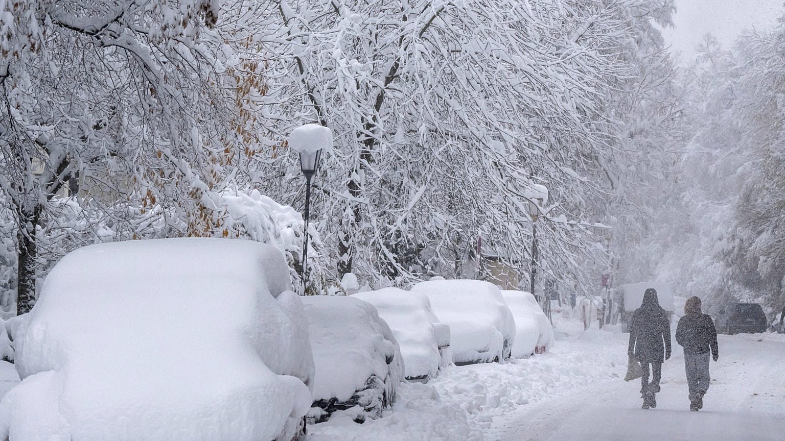 People walk following a heavy snowfall in Munich, Germany Saturday, Dec. 2, 2023