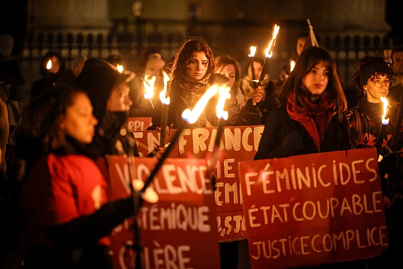 Women with torches and placards protest in front of the Pantheon to mark the international day for the elimination of violence against women in Paris, 25 November, 2025