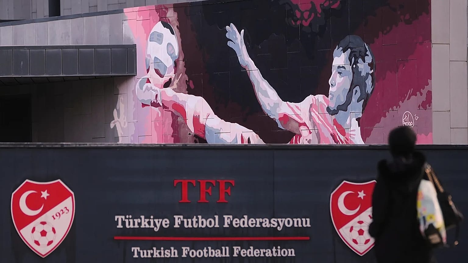 A woman walks outside the Turkish Football Federation headquarters in Istanbul, 12 November, 2025