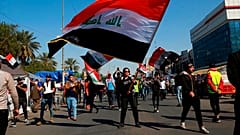 طلاب ومتظاهرون آخرون يرفعون أعلامًا وطنية خلال احتجاج في ساحة التحرير ببغداد، العراق، الخميس 6 فبراير/شباط 2020.