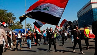 طلاب ومتظاهرون آخرون يرفعون أعلامًا وطنية خلال احتجاج في ساحة التحرير ببغداد، العراق، الخميس 6 فبراير/شباط 2020.