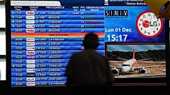 Un passager regarde le tableau d'information des vols à l'aéroport international Simon Bolivar de Maiquetia, au Venezuela, le 1er décembre 2025.