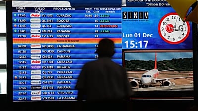 Um passageiro olha para o quadro de informações de voo no Aeroporto Internacional Simon Bolivar em Maiquetia, Venezuela, em 1 de dezembro de 2025.