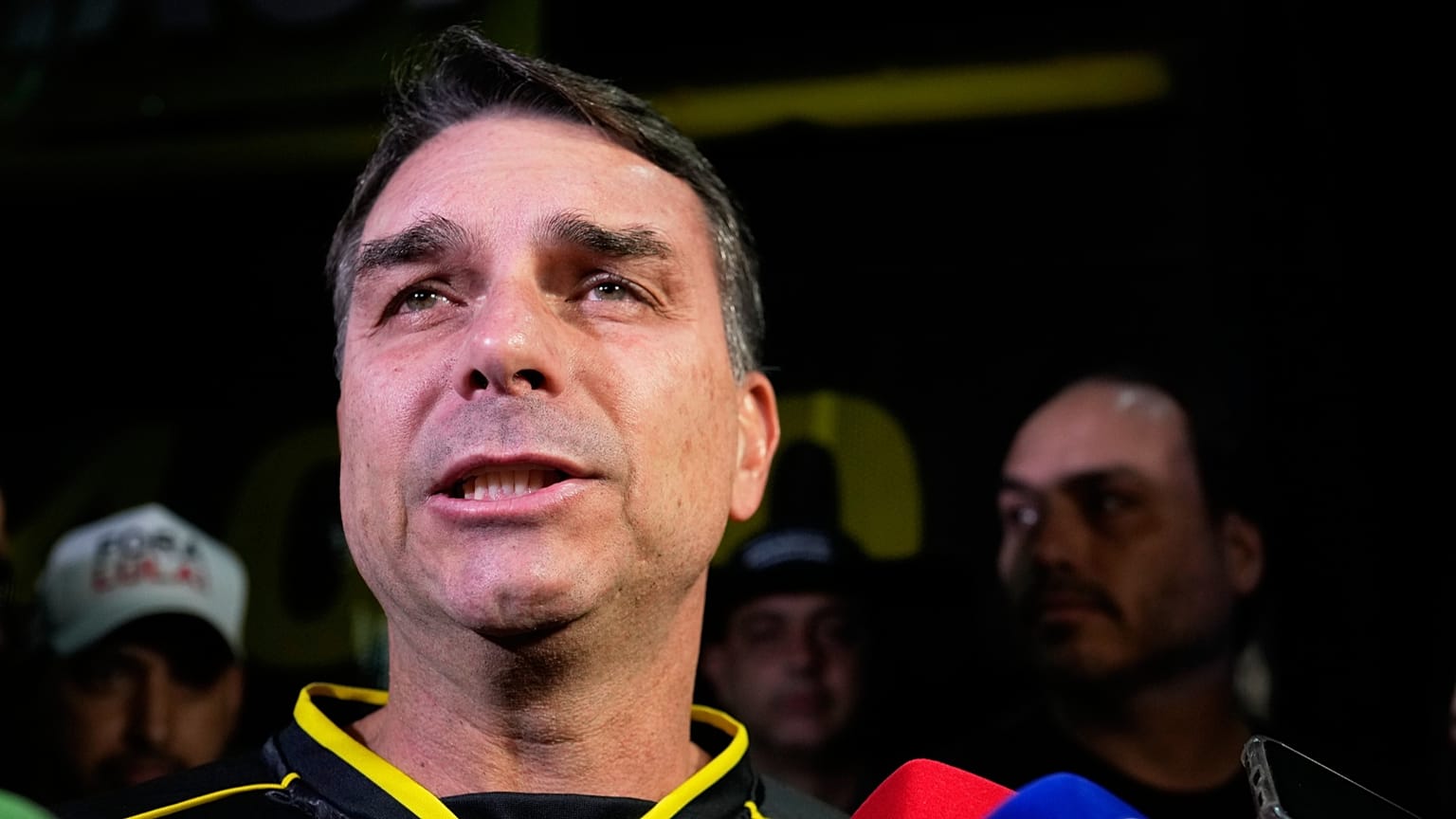 Flavio Bolsonaro, filho do ex-presidente Jair Bolsonaro, fala durante uma vigília em frente à residência do ex-presidente em Brasília, Brasil, sábado, 22 de novembro de 2025.