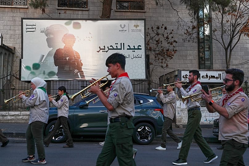  فرقة كشفية تستعرض في أحد الشوارع خلال احتفالات الذكرى السنوية الأولى للإطاحة بنظام بشار الأسد في دمشق، سوريا، الأحد 7 ديسمبر/كانون الأول 2025.