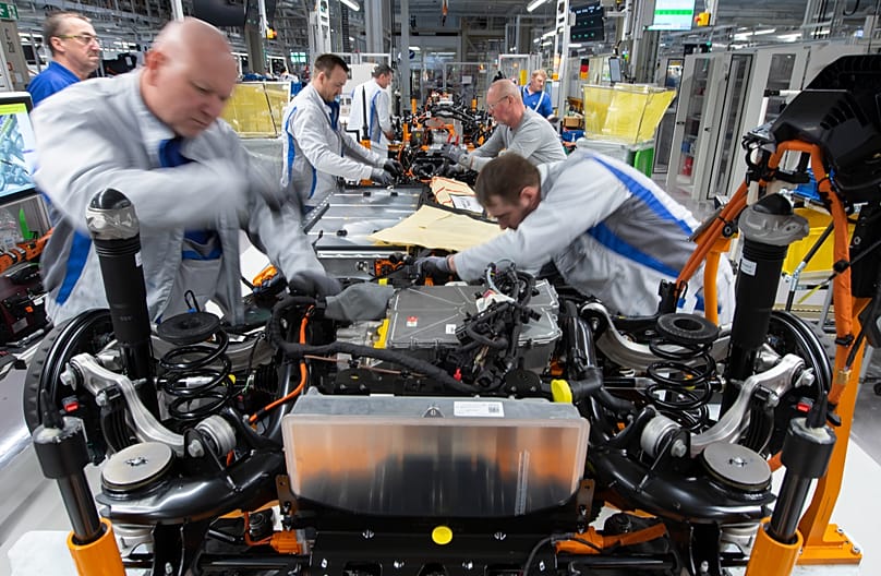 Workers complete an electric car ID.3 body at the assembly line during a press tour at the plant of the German manufacturer Volkswagen AG (VW) in Zwickau, Germany, 2020.
