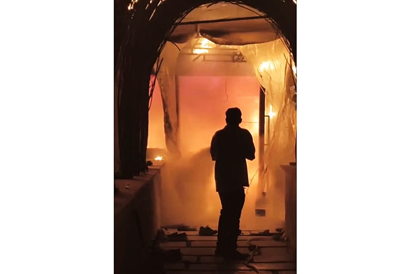 A fire fighter attempts to contain a fire at a nightclub early Sunday, in Arpora, in Goa, India, Sunday, 7 December 7 2025.