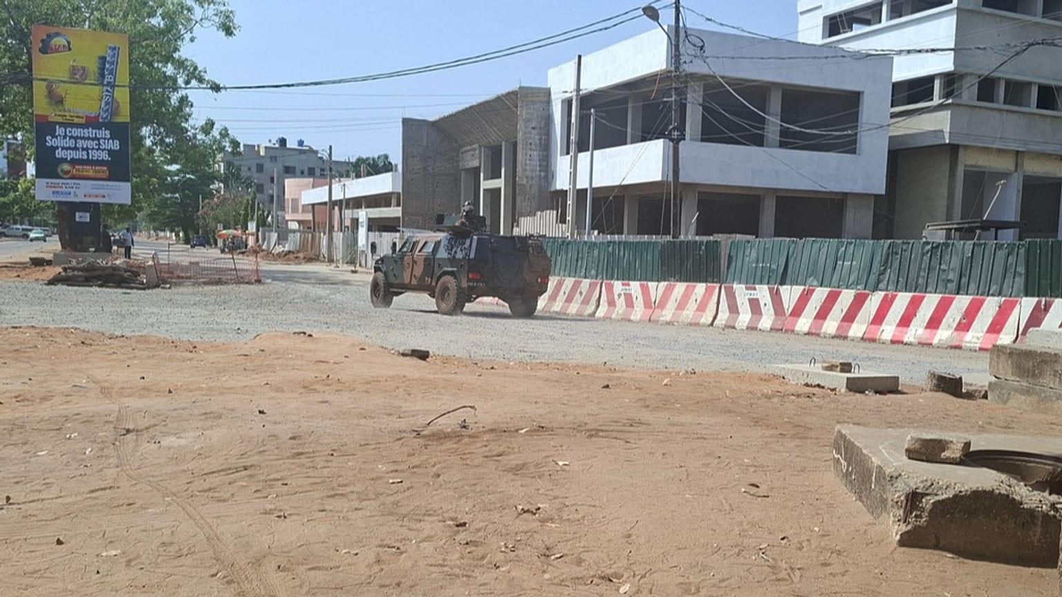 Des soldats circulent dans un véhicule militaire le long d'une rue lors d'une tentative de coup d'État à Cotonou au Bénin, le dimanche 7 décembre 2025.