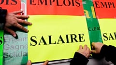 Des fonctionnaires collent des pancartes « Emploi » (en haut) et « Salaire » lors d'une manifestation sur les salaires, à Lille, dans le nord de la France. 2 févr. 2006.