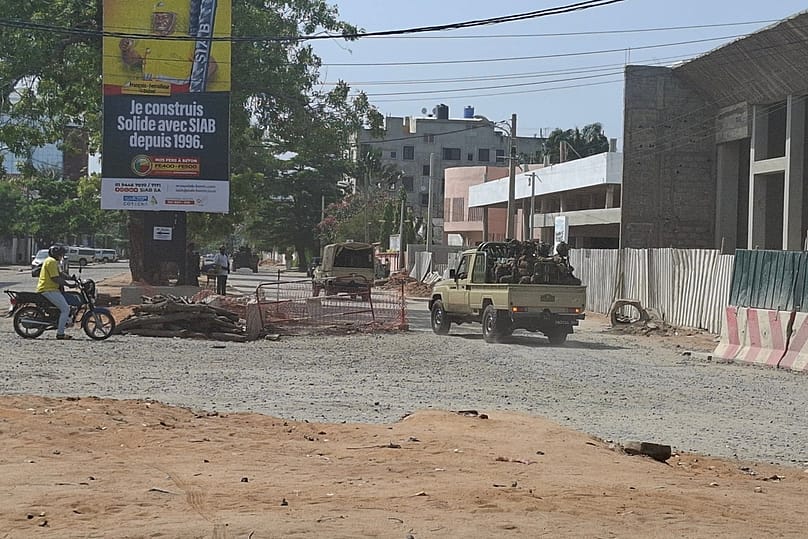 Soldiers ride in a military vehicle along a street amid an attempted coup in Cotonou Benin, Sunday Dec. 6, 2025.