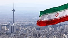 ترفرف الراية الوطنية الإيرانية بينما يظهر برج ميلاد للاتصالات وعدد من المباني في طهران، إيران، يوم الثلاثاء 31 مارس 2020.