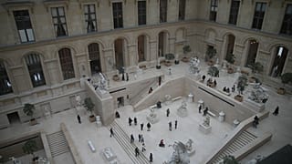 Visiteurs dans l'aile Richelieu du musée du Louvre, mercredi 19 novembre 2025 à Paris. (AP Photo/Christophe Ena)