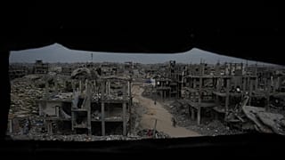  فلسطينيون وسط الدمار الذي خلّفه الهجوم الجوي والبري الإسرائيلي في جباليا، شمالي قطاع غزة، يوم السبت 6 ديسمبر/كانون الأول 2025. 