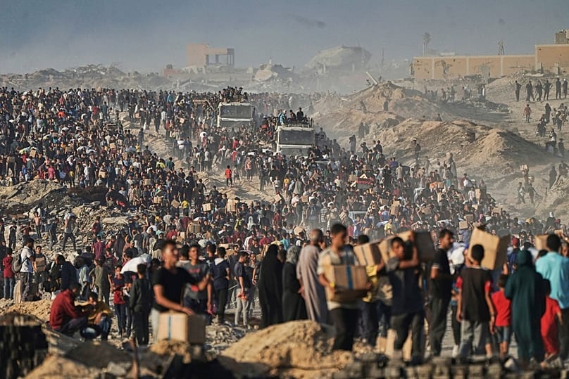 FILE - People carry sacks and boxes of food and humanitarian aid that was unloaded from a World Food Program convoy in the northern Gaza Strip, June 16, 2025.