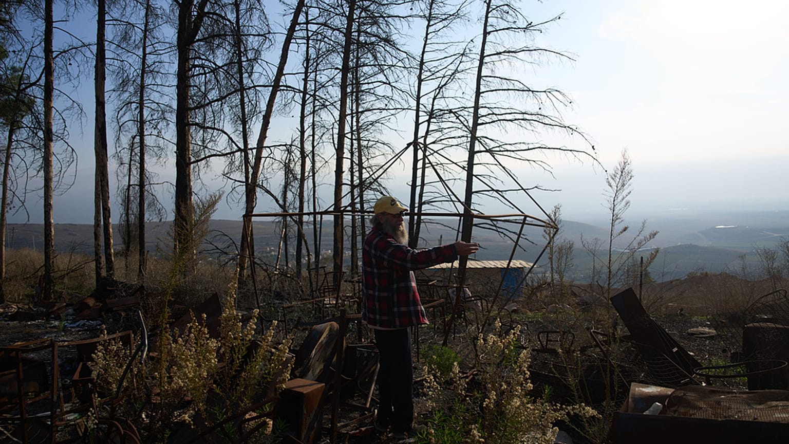 يمشي إيلان روزنفلد بين أنقاض متجره المحترق في المطلة، وهي بلدة صغيرة متضررة من الحرب تقع على الحدود الإسرائيلية-اللبنانية، يوم الأحد 30 نوفمبر 2025