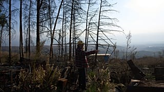 يمشي إيلان روزنفلد بين أنقاض متجره المحترق في المطلة، وهي بلدة صغيرة متضررة من الحرب تقع على الحدود الإسرائيلية-اللبنانية، يوم الأحد 30 نوفمبر 2025