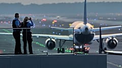 Αστυνομικοί παρακολουθούν τα αεροσκάφη να παίρνουν τις θέσεις στάθμευσής τους στο αεροδρόμιο της Φρανκφούρτης, Γερμανία.