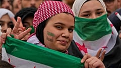فتيات يرفعن لافتات النصر أثناء تجمعهن للاحتفالات بالذكرى الأولى للإطاحة بالرئيس السابق بشار الأسد في دمشق، سوريا، الاثنين 8 ديسمبر 2025. 