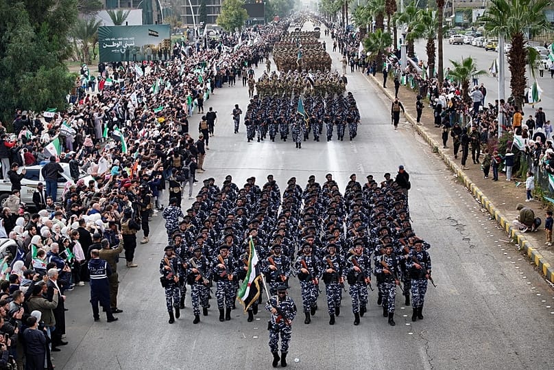 جنود الجيش السوري الجديد يسيرون خلال موكب بمناسبة الذكرى الأولى للإطاحة بنظام بشار الأسد في دمشق, سوريا, الإثنين, ديسمبر. 8, 2025. 