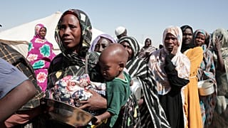 A darfuri El-Faserből elüldözött nők állnak sorban élelmiszersegélyért az északi Al Dabbah menekülttáborban