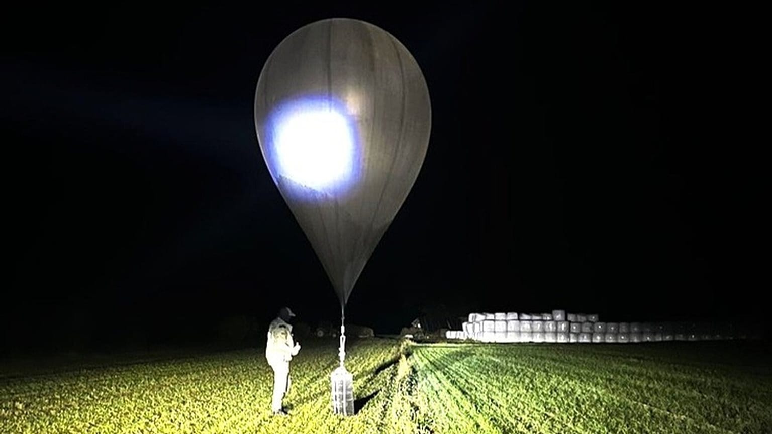FILE: In this undated photo released by Lithuania's State Border Guard Service, an officer inspects a balloon used to carry cigarettes into Lithuania