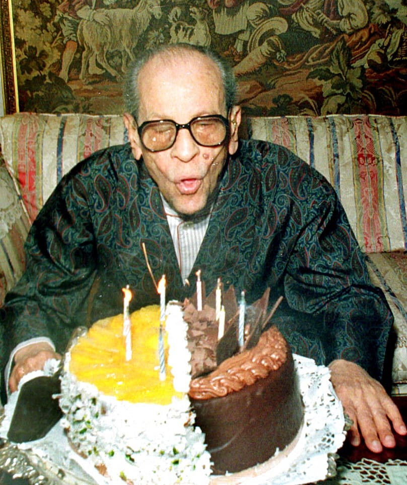 نجيب محفوظ، الروائي المصري والحائز على جائزة نوبل عام 1988، يطفئ شموع كعكة عيد ميلاده الـ88 في هذه الصورة المؤرخة في 11 ديسمبر 1998، في القاهرة، مصر