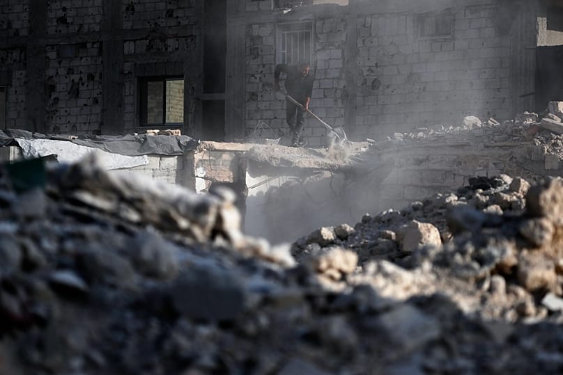 رجل يزيل الأنقاض من مبنى دمرته الحرب في ضاحية داريا بدمشق, سوريا, يوم الجمعة, ديسمبر. 5, 2025.