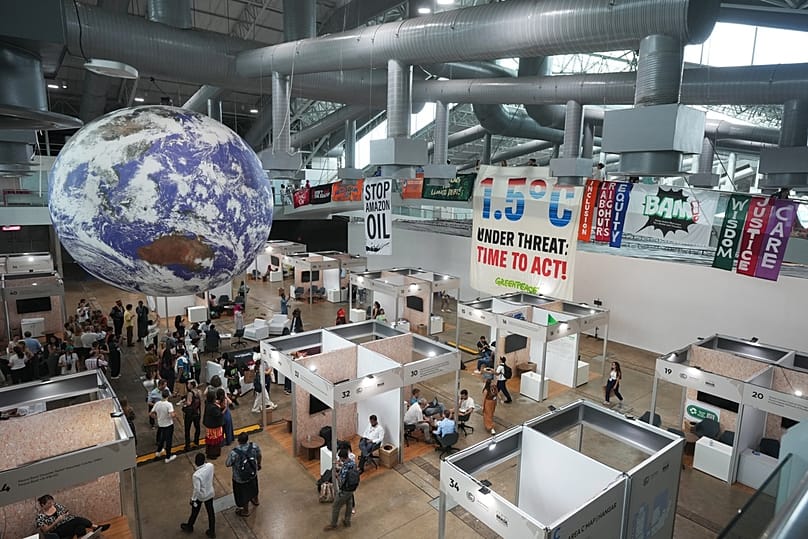 ناشطون يعلّقون لافتات خلال مشاركتهم في تظاهرة ضمن قمة المناخ COP30 في مدينة بيليم البرازيلية، في 21 نوفمبر 2025.