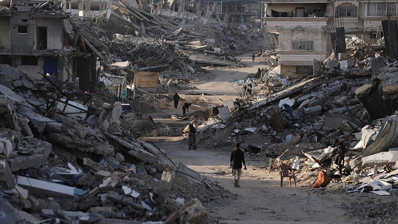 يمشي أشخاص بين المباني المدمرة في جباليا، شمال قطاع غزة، يوم الأحد 7 ديسمبر 2025. (تصوير: جيهاد الشريف / أسوشيتد برس)