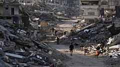 يمشي أشخاص بين المباني المدمرة في جباليا، شمال قطاع غزة، يوم الأحد 7 ديسمبر 2025. (تصوير: جيهاد الشريف / أسوشيتد برس)