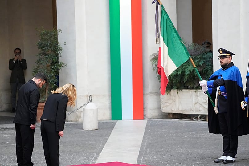 الرئيس الأوكراني فولوديمير زيلينسكي ورئيسة الوزراء الإيطالية جورجيا ميلوني يؤدّيان التحية في قصر شيغي في 20 نوفمبر 2025.