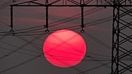 The sun rises behind electrical power lines in Frankfurt, Germany.