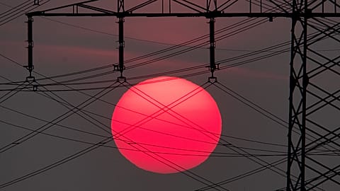 The sun rises behind electrical power lines in Frankfurt, Germany.