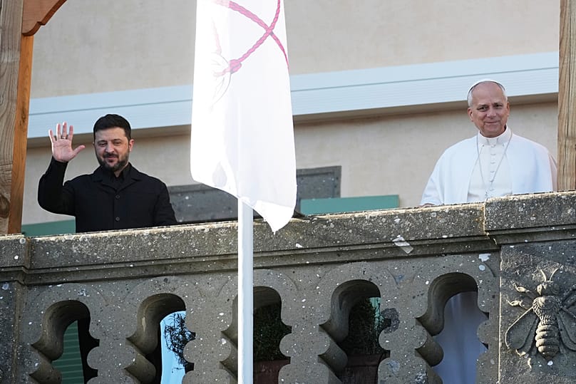 الرئيس الأوكراني فولوديمير زيلينسكي والبابا ليو الرابع عشر يلوّحان للصحفيين خلال لقائهما في كاستل غاندولفو بإيطاليا، الثلاثاء 9 كانون الأول/ديسمبر 2025.