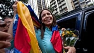 María Corina Machado sostiene la bandera venezolana frente a la Fiscalía General de la República en Caracas, Venezuela, el miércoles 3 de diciembre de 2014.
